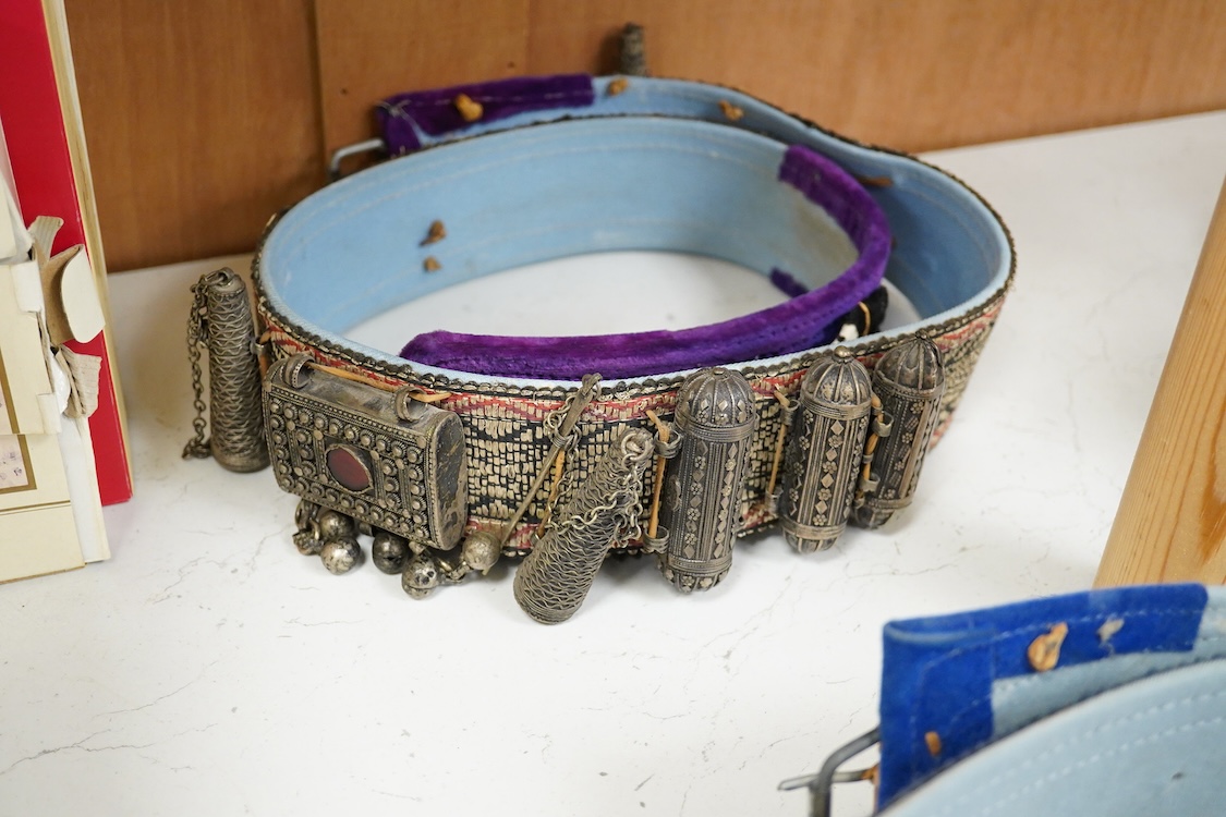 Two Yemeni white metal daggers white and two belts, largest dagger 31cm long